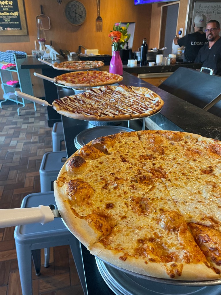 Fresh pizzas and slices at Local Pie in Kendall